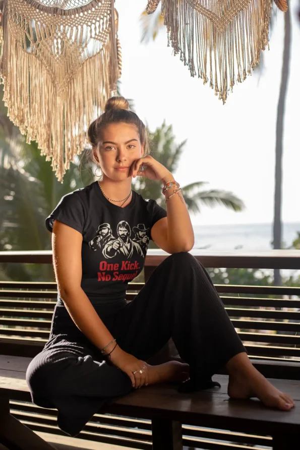 Koszulka Chuck Norris z filmowym nadrukiem | czarny t-shirt damski 3 Koszulka Chuck Norris z filmowym nadrukiem | czarny t-shirt damski tee mockup of a woman with a hair bun sitting on a bench by the beach 26863 2