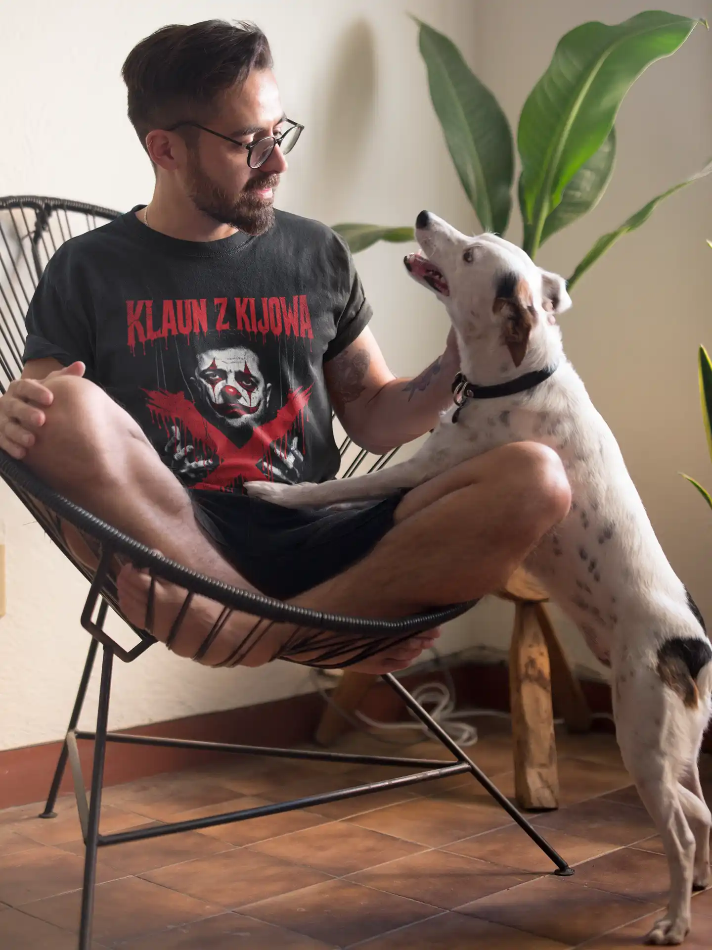 tee-mockup-of-a-man-sitting-on-an-acapulco-chair-petting-his-dog-18085